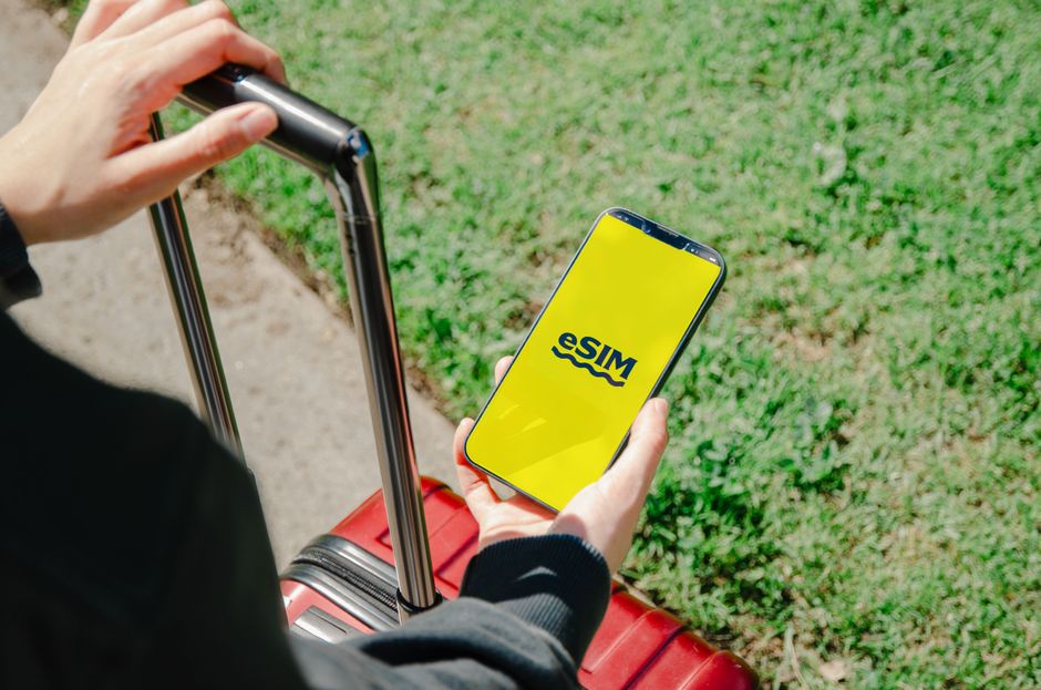 Person holding smartphone with eSIM